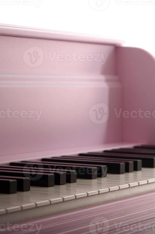 Close-up of the keyboard of a pink piano. Set of white and black buttons photo