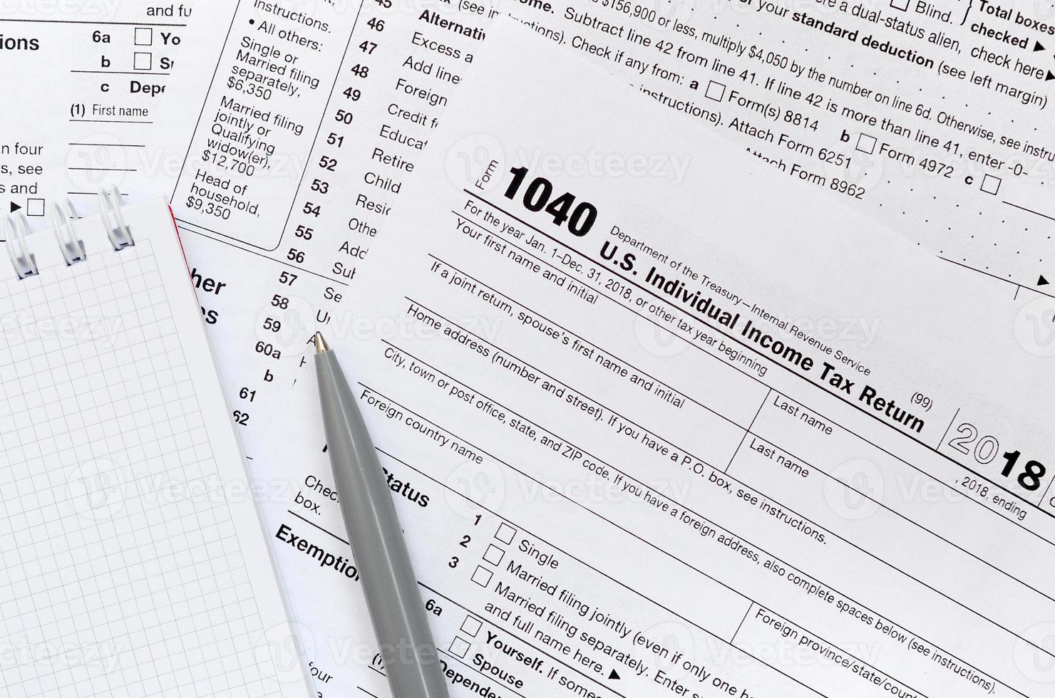 The pen and notebook is lies on the tax form 1040 U.S. Individual