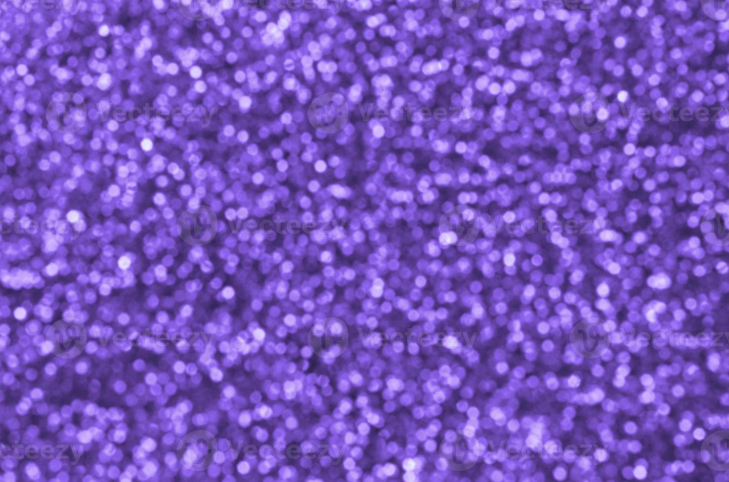 Blurred violet decorative sequins. Background image with shiny bokeh lights from small elements photo