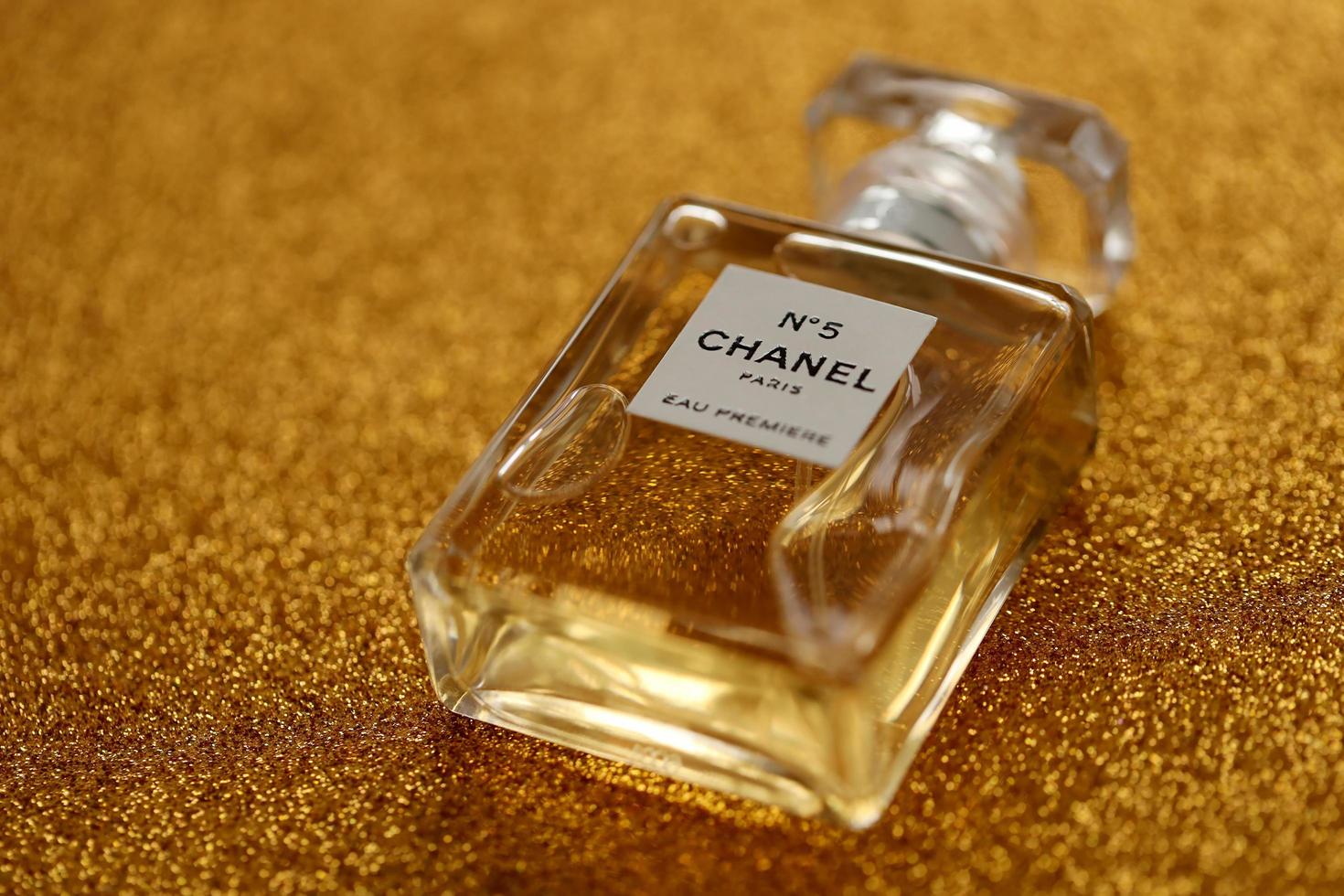 TERNOPIL, UKRAINE - SEPTEMBER 2, 2022 Chanel Number 5 Eau Premiere worldwide famous french perfume bottle on shiny glitter background in purple colors photo
