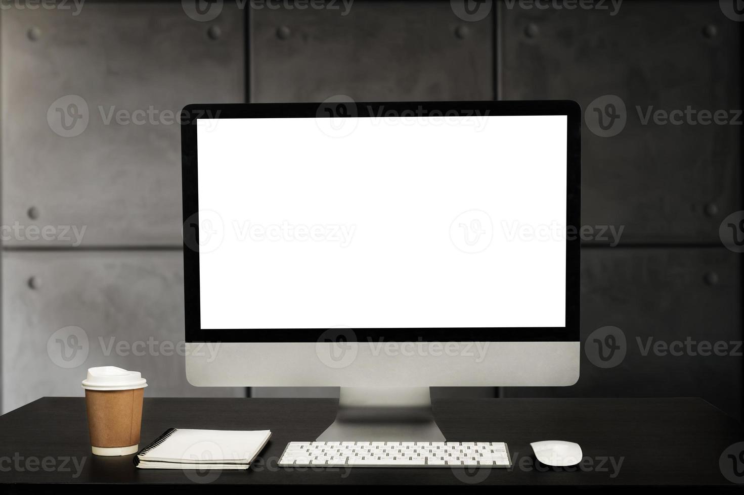 vista de cerca de la computadora de pantalla en blanco, suministros de oficina y decoración en el escritorio blanco con fondo de sala de oficina modren borroso foto