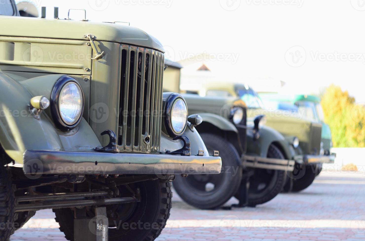 Photo of the cabins of three military off-road vehicles from the times of the Soviet Union. Side view of military cars from the front wheel