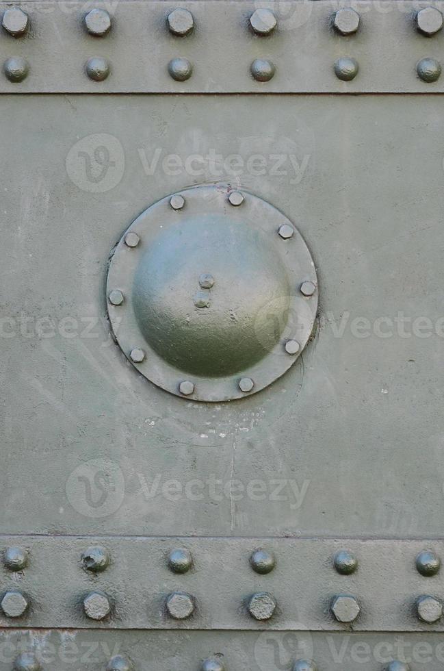 The texture of the wall of the tank, made of metal and reinforced with a multitude of bolts and rivets. Images of the covering of a combat vehicle from the Second World War photo