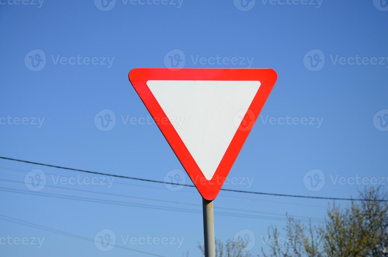 Traffic sign in the form of a white triangle. Give way photo