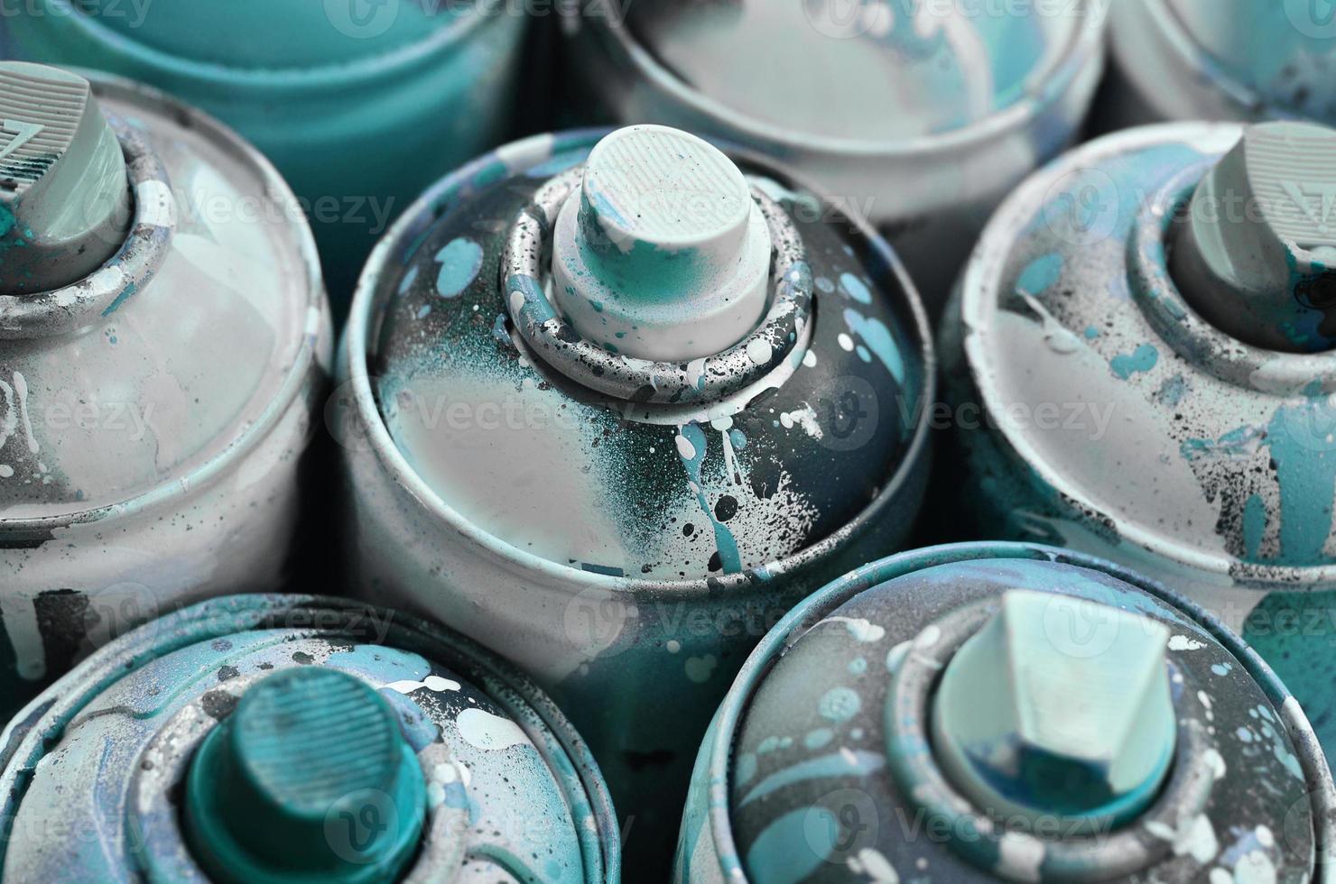 A lot of used spray cans of paint close-up. Dirty and smeared cans for drawing graffiti. The concept of a sweeping and careless drawing of paint. Creative art image photo