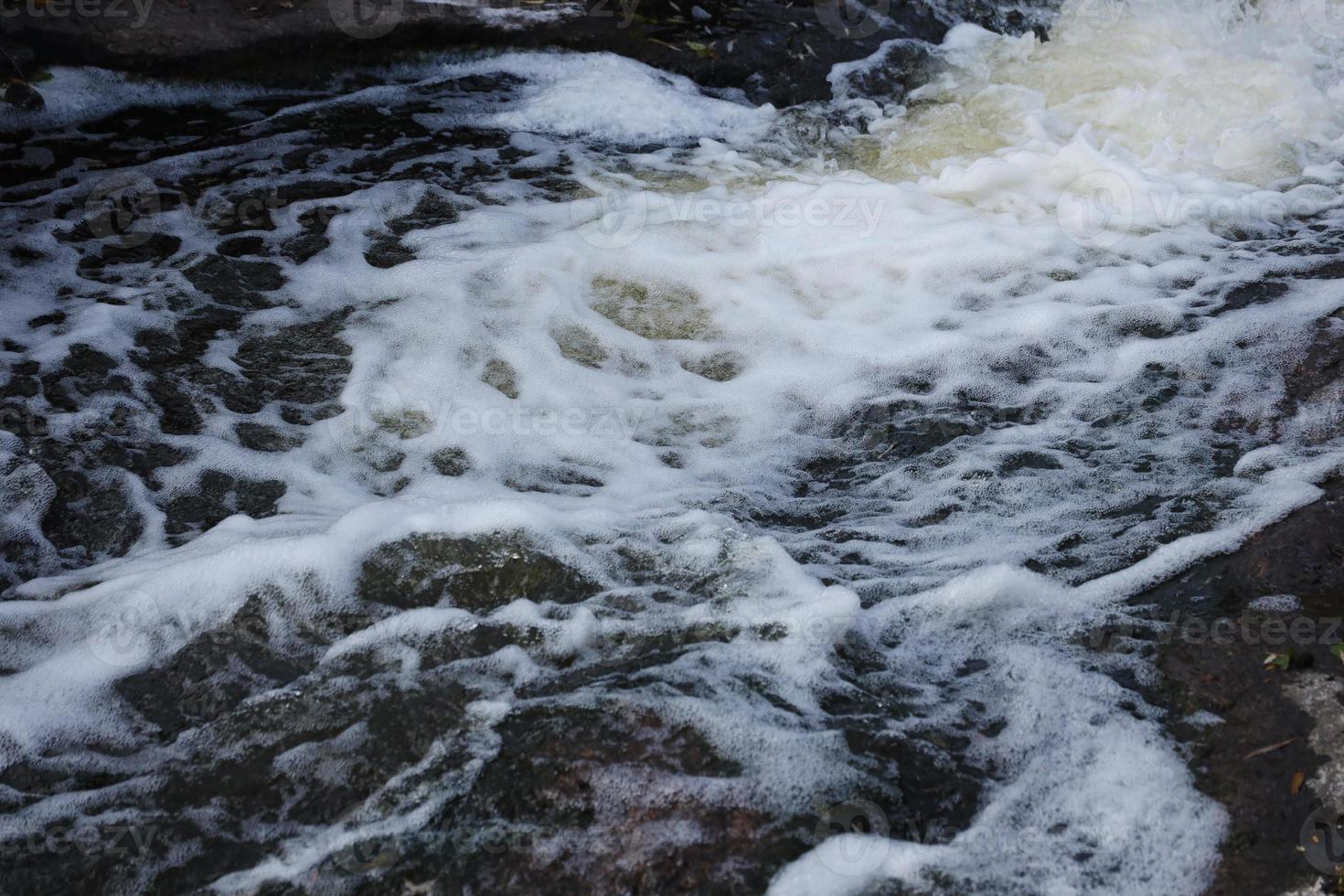 Waves of water of the river and the sea meet each other during high tide and low tide. Deep blue stormy sea water surface with white foam and waves pattern, background photo