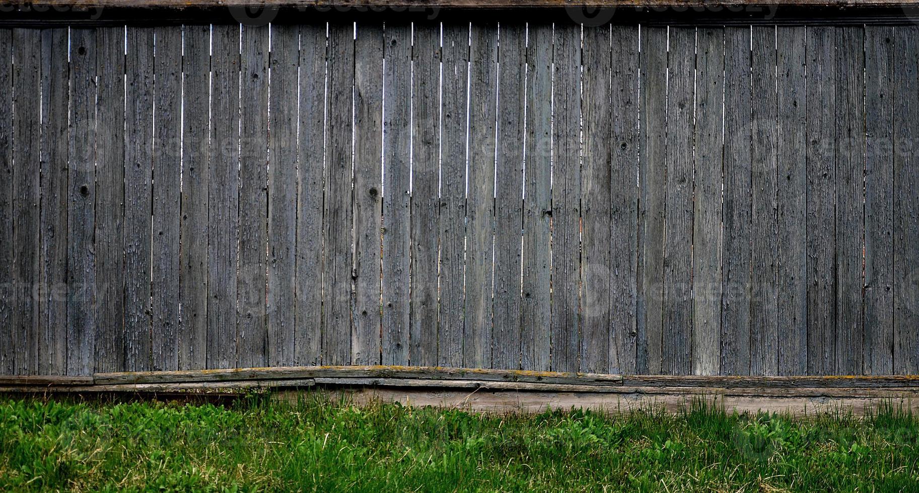 The texture of an old rustic wooden fence made of flat processed boards photo