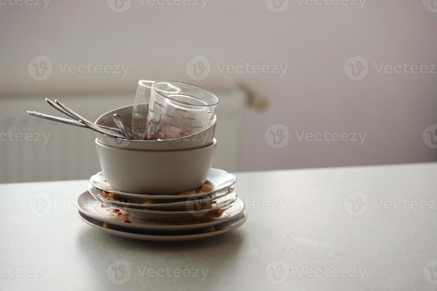 Stack of dirty dishes with food leftovers on the table after meal. Banquet ending concept. Unwashed dishes photo