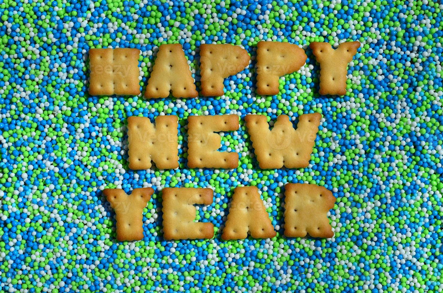 Happy New Year. The word from the edible letters lies on the glazed powder photo