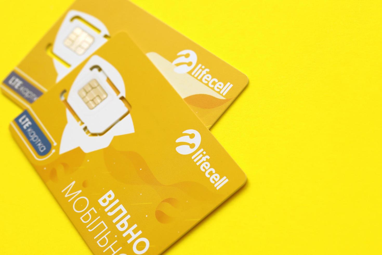 TERNOPIL, UKRAINE - JULY 5, 2022 Lifecell new sim card with free contract on yellow background. Lifecell is ukrainian mobile telephone network operator and provider of wireless connection photo