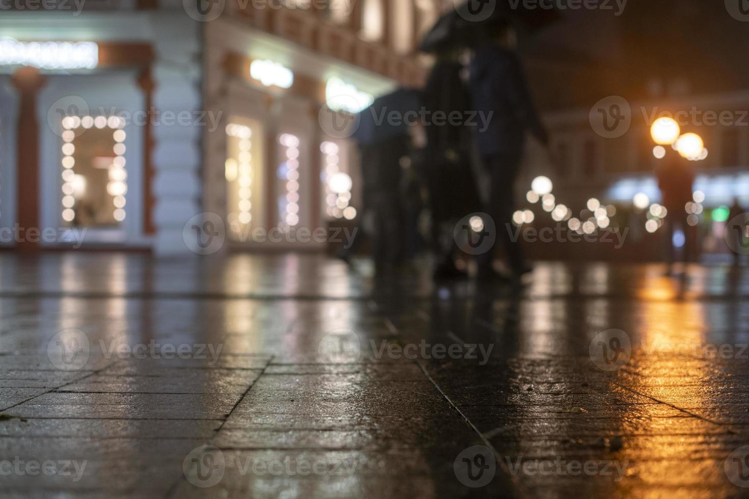 Night urban landscape, colored lights reflected in the wet asphalt in fall. Rainy night street in the city. The lights of a rainy night in the autumn city of disfocus and bokeh. Neon street. photo