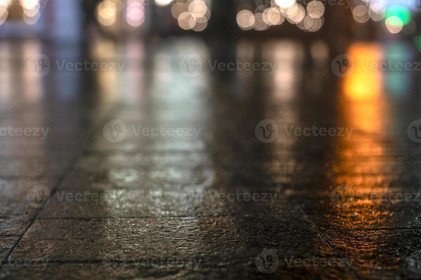 Night urban landscape, colored lights reflected in the wet asphalt in fall. Rainy night street in the city. The lights of a rainy night in the autumn city of disfocus and bokeh. Neon street. photo