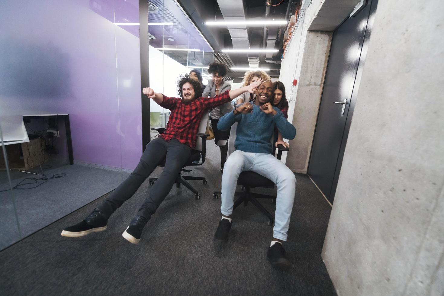 multiethnics business team racing on office chairs photo