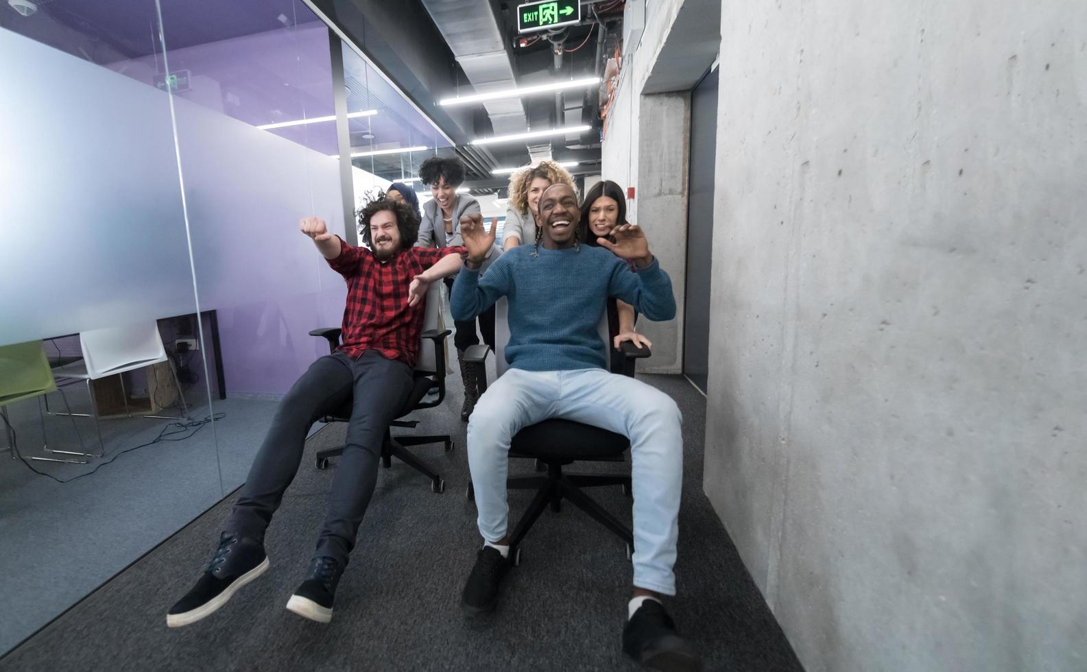 multiethnics business team racing on office chairs photo