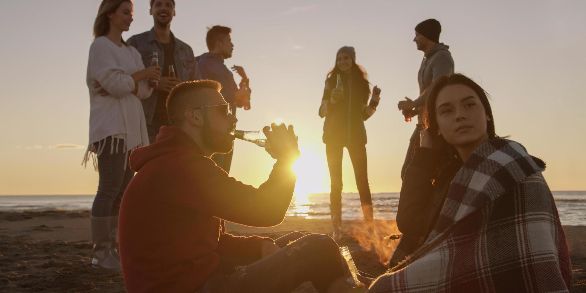 Friends having fun at beach on autumn day photo