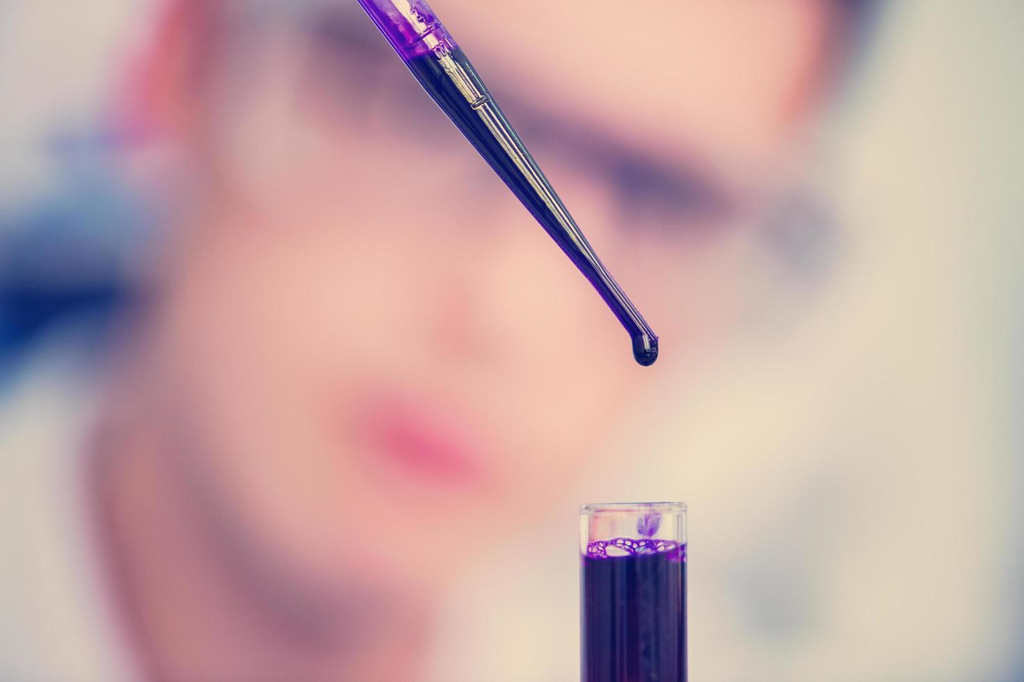 student with protective glasses making chemistry experiment photo