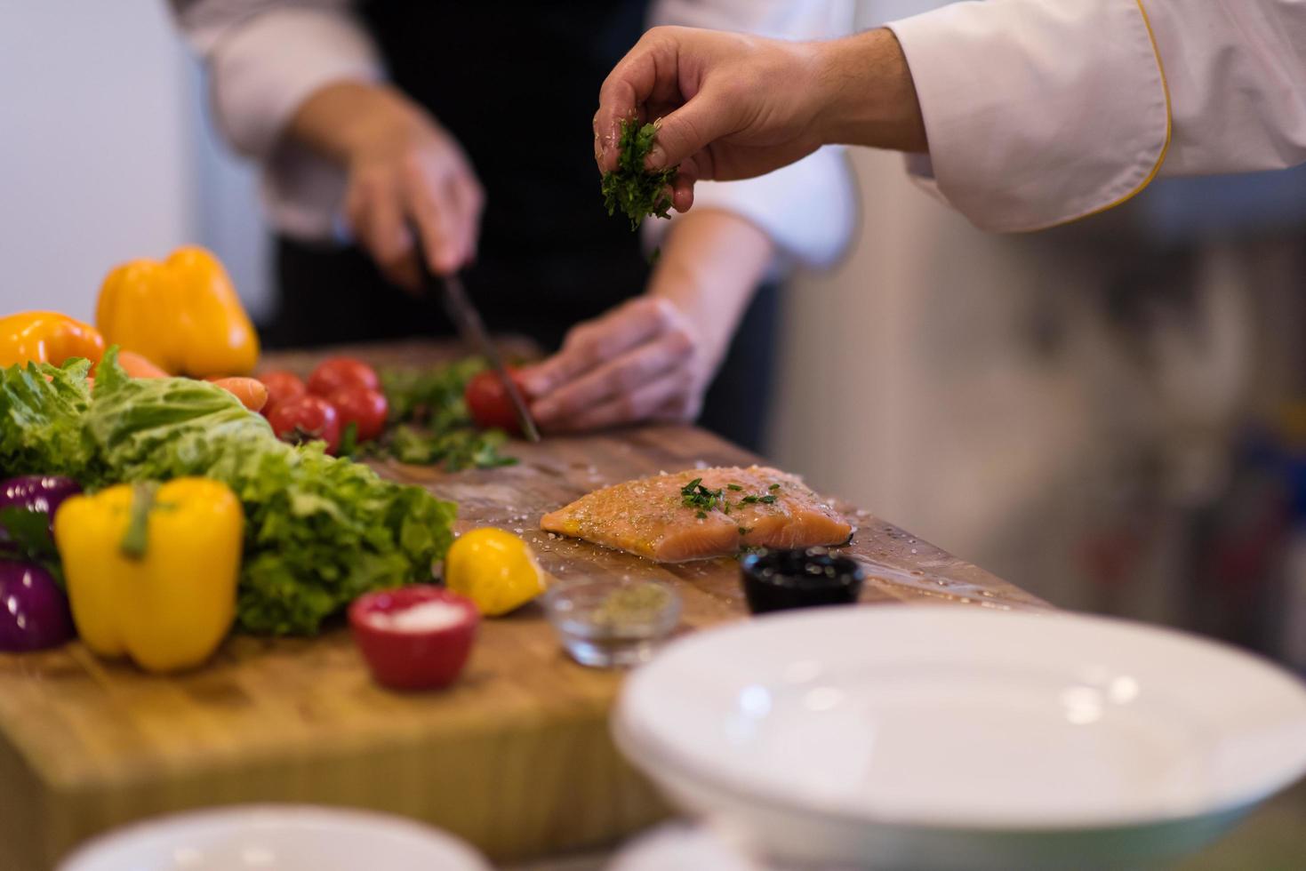 Chef hands preparing marinated Salmon fish photo