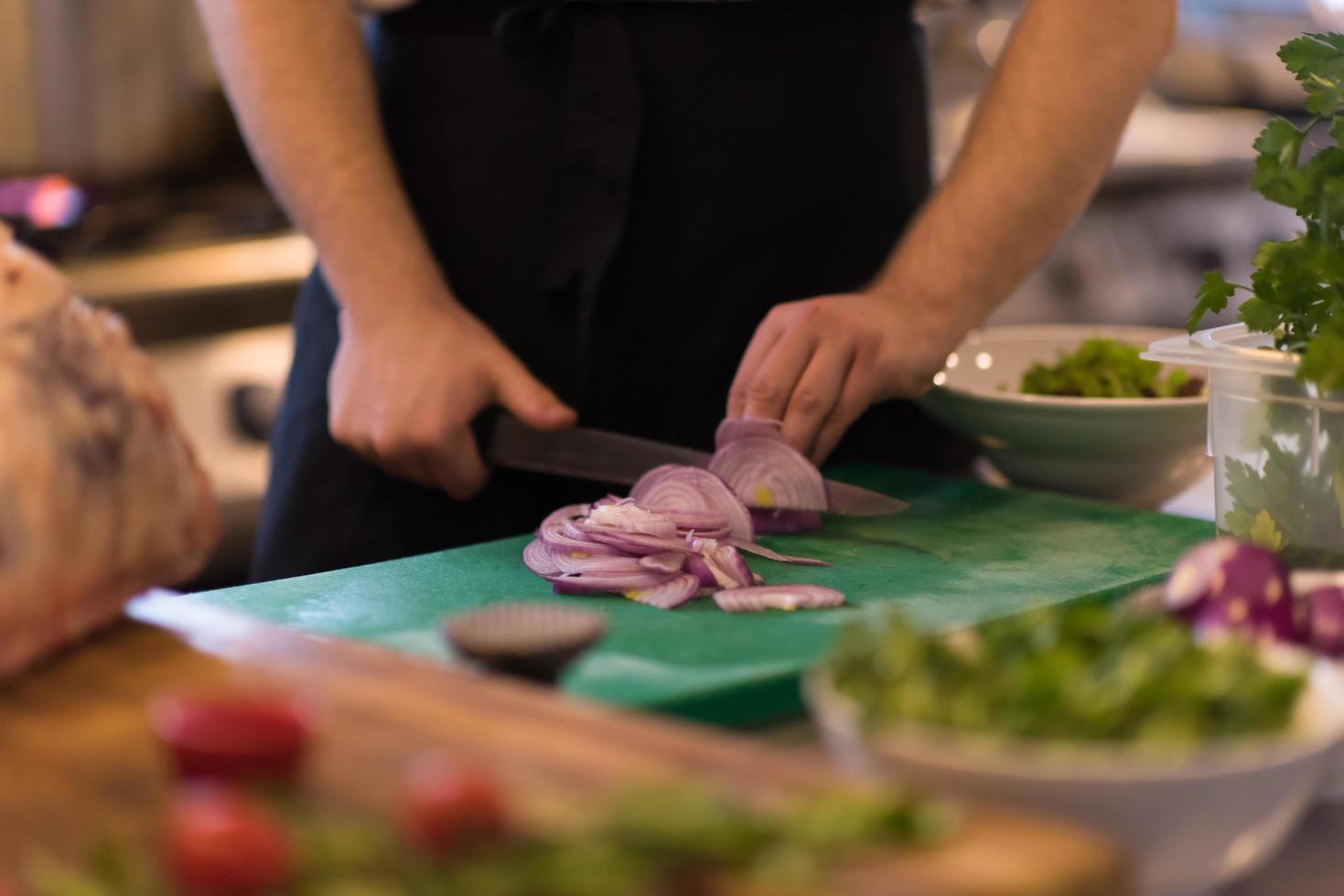 chef manos cortando la cebolla con cuchillo foto