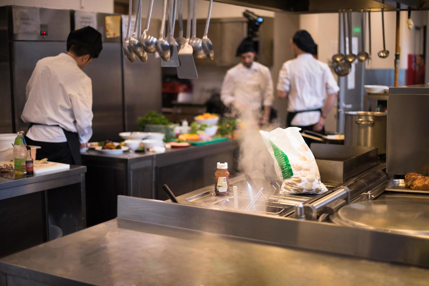 equipo de cocineros y chefs preparando comida foto