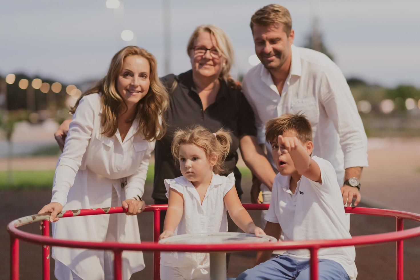 An elderly couple in casual clothes with their children and grandmother spend time together in the park on vacation. Family time. Selective focus photo