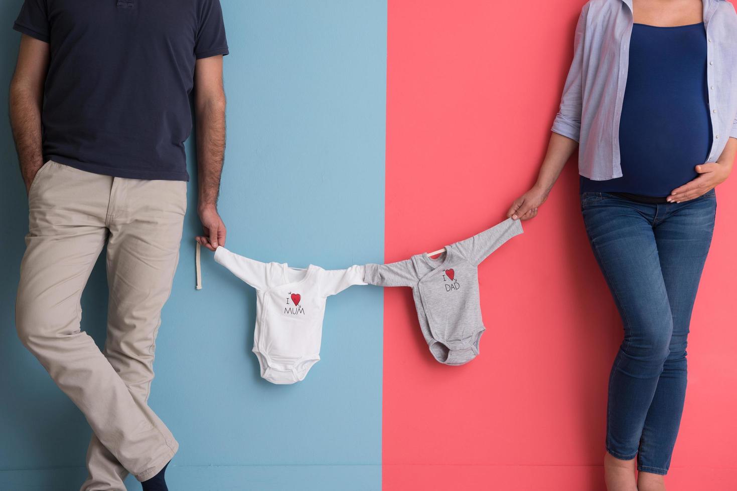 young couple holding baby bodysuits photo