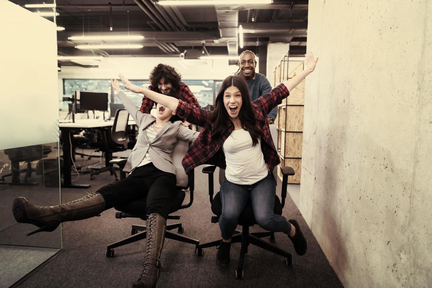 equipo de negocios multiétnico corriendo en sillas de oficina foto