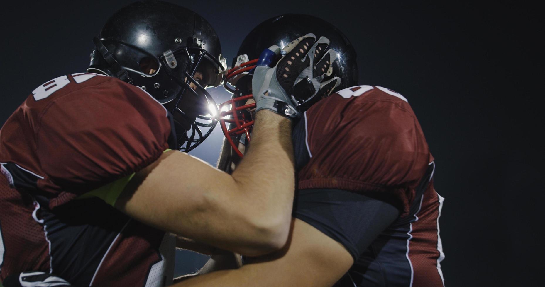 American football players knocking with helmets and having fun photo