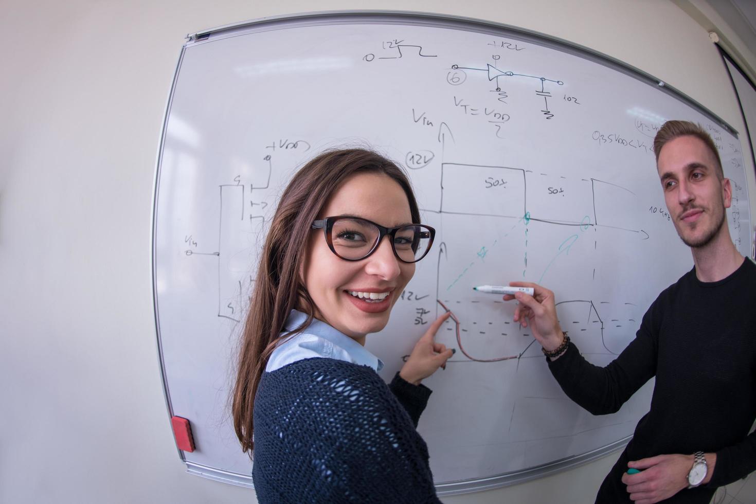 students writing on the white chalkboard photo