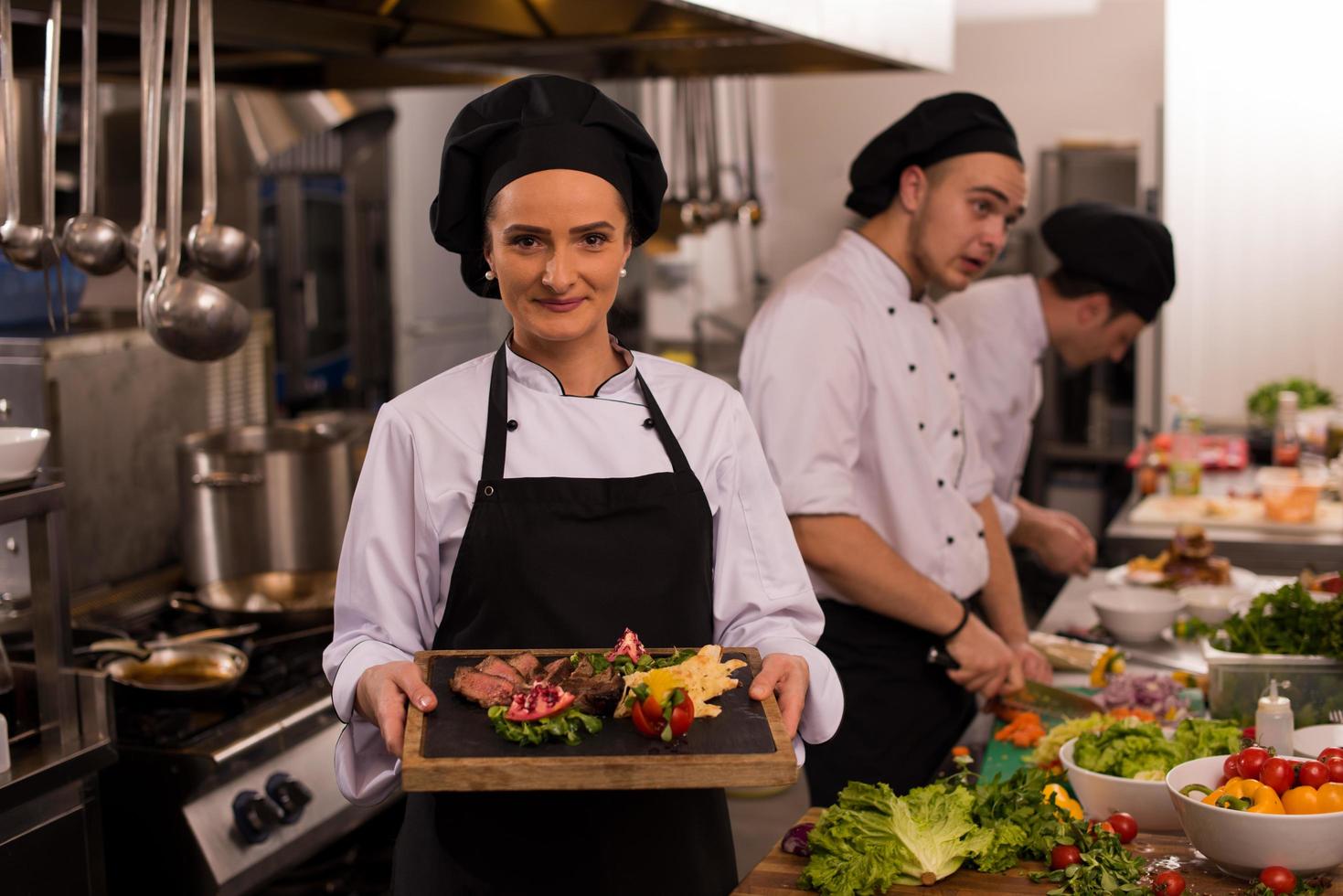 female Chef holding beef steak plate photo