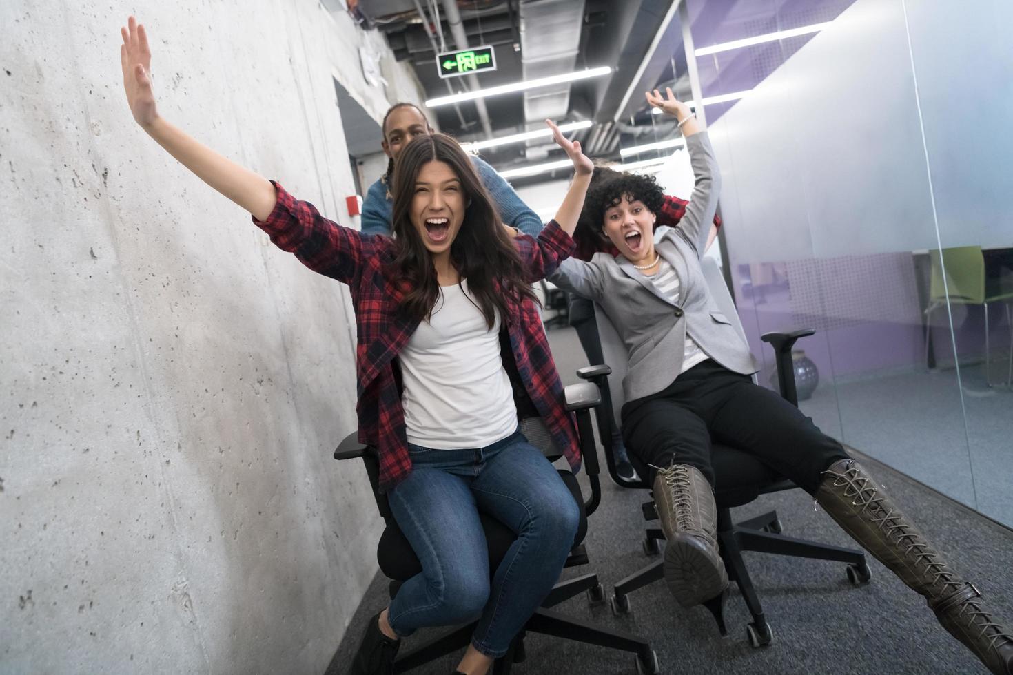 multiethnics business team racing on office chairs photo