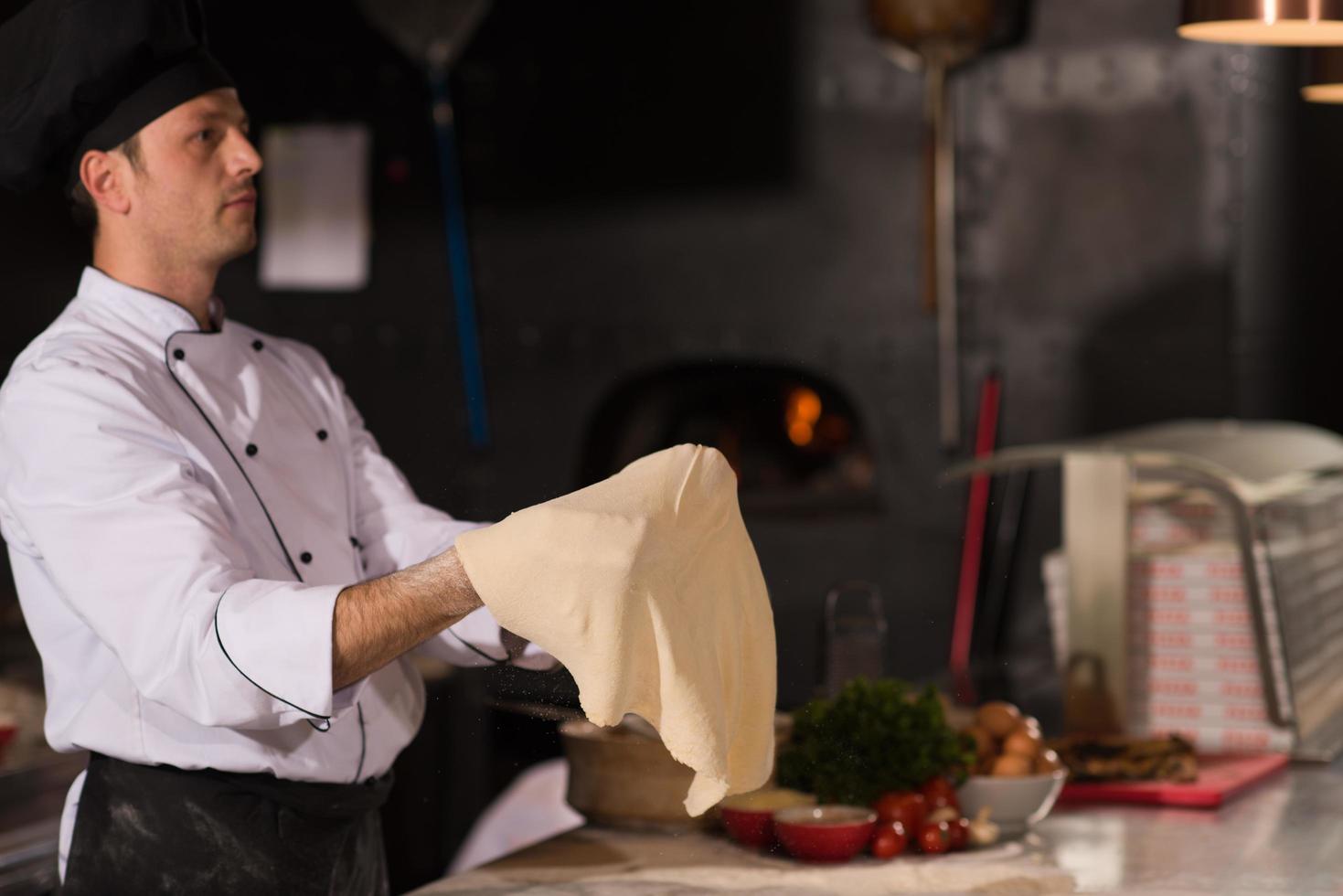 chef throwing up pizza dough photo