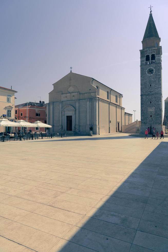 Umag town in Croatia, main square with church and tower at dusk photo