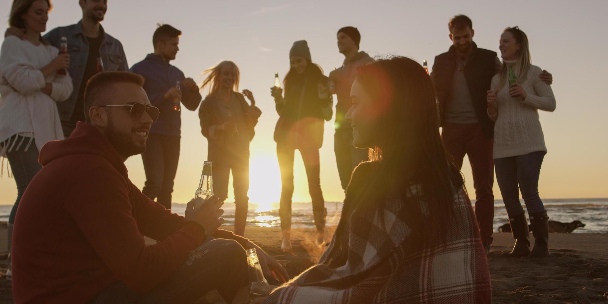 Friends having fun at beach on autumn day photo