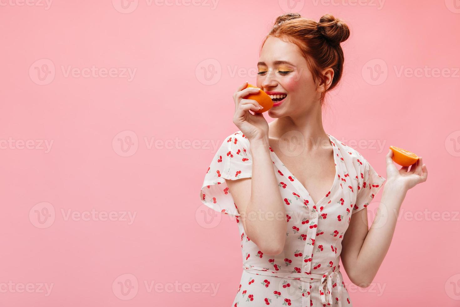 retrato de niña con sombras amarillas en los ojos posando con naranjas. mujer vestida con cerezas smil foto