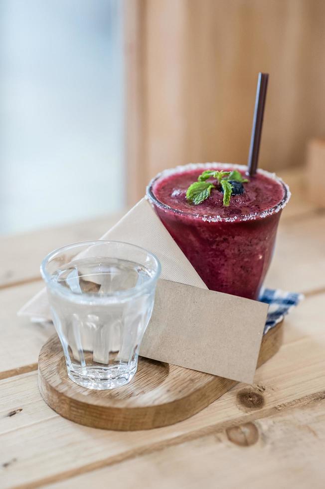 Blueberry smoothie on the table and blank card - soft focus point photo