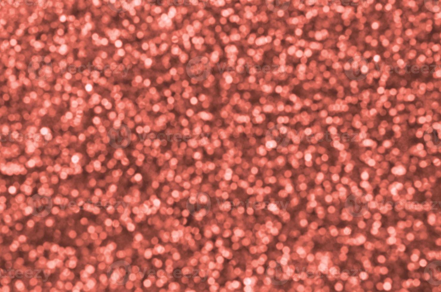 Blurred orange decorative sequins. Background image with shiny bokeh lights from small elements photo