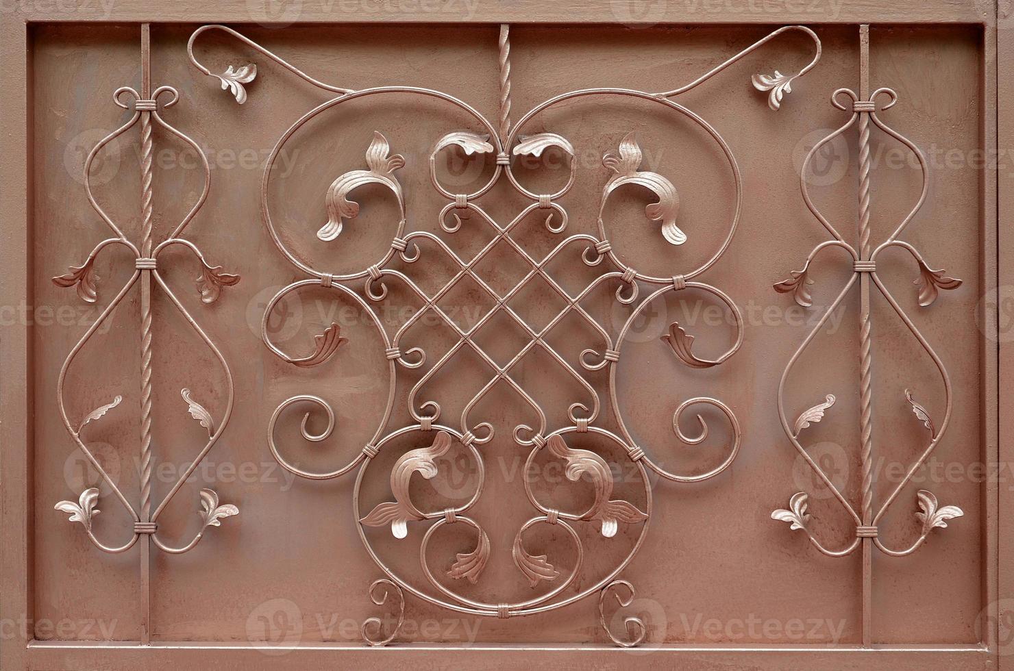 The texture of the bronze metal gate with a beautiful floral pattern of forged metal photo