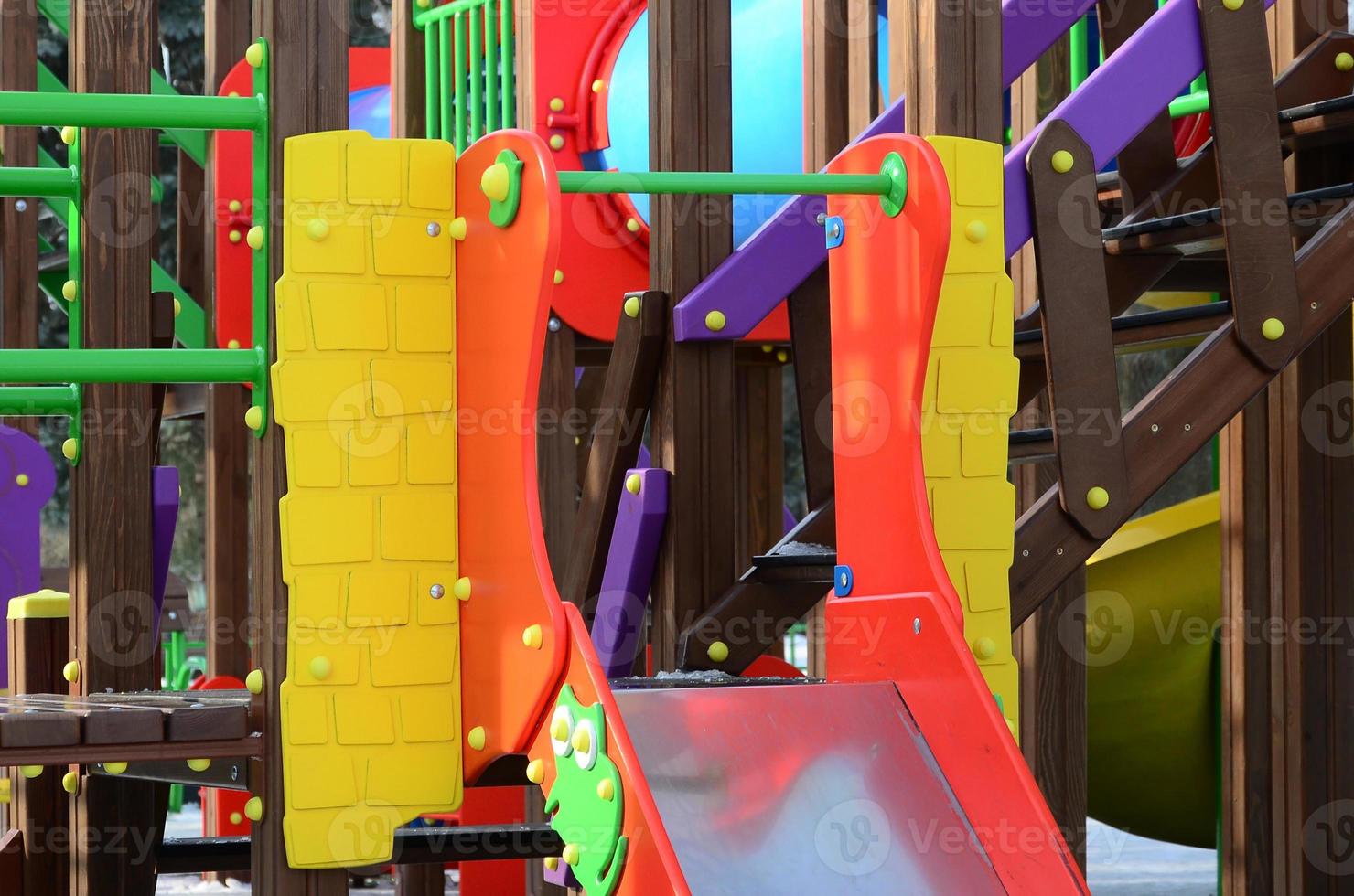 Fragment of a playground made of plastic and wood, painted in different colors photo