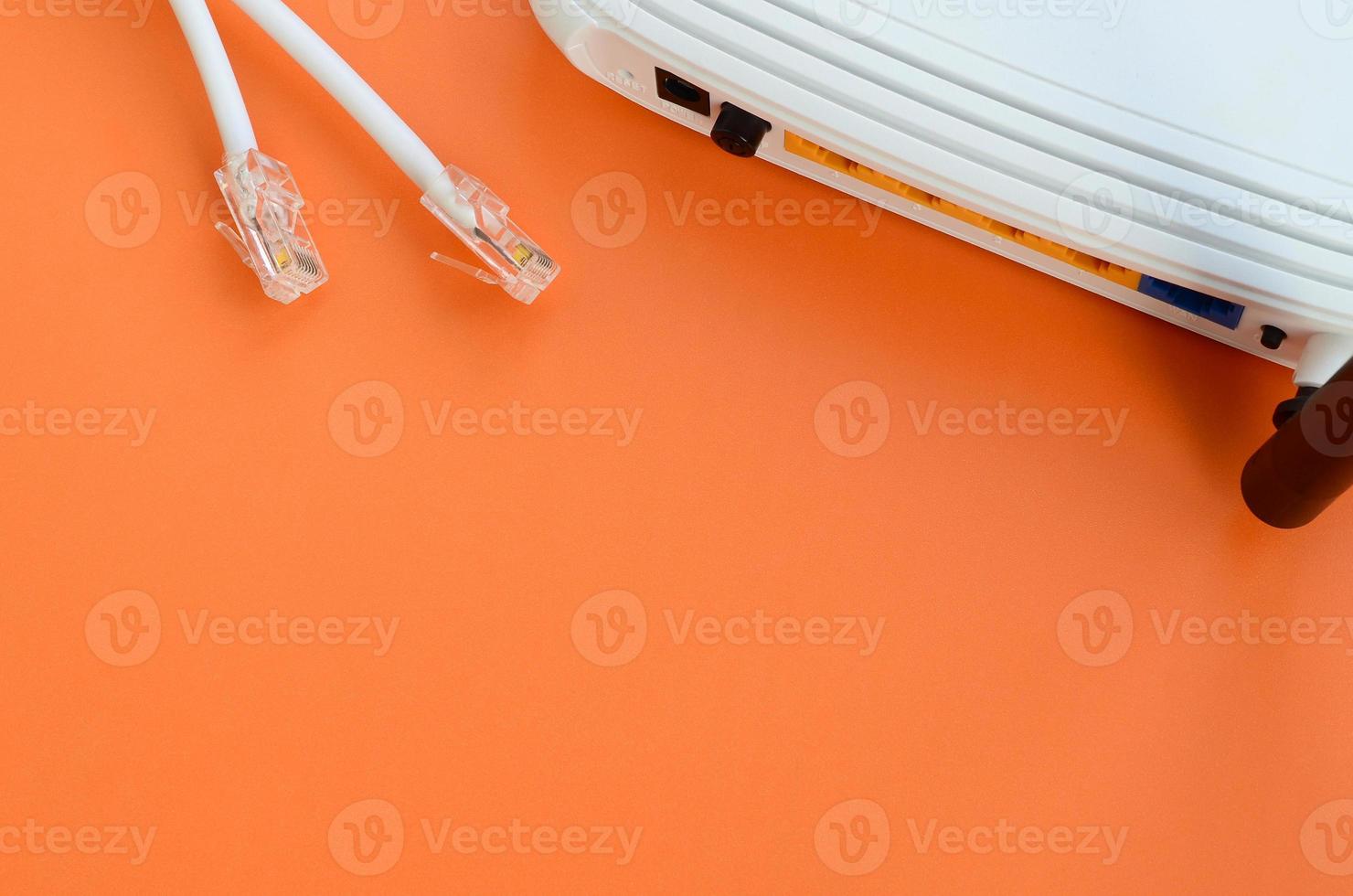 Internet router and Internet cable plugs lie on a bright orange background. Items required for Internet connection photo