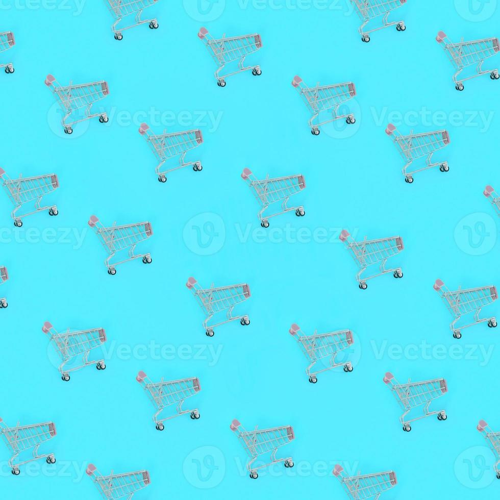 Shopping addiction, shopping lover or shopaholic concept. Many small empty shopping carts perform a pattern on a pastel colored paper background. Flat lay composition, top view photo