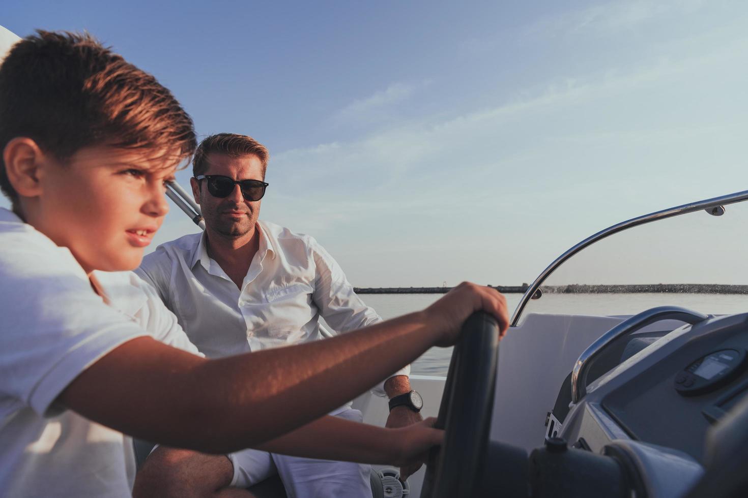 Father and son enjoy their vacation together while riding a luxury boat at sea. Selective focus photo