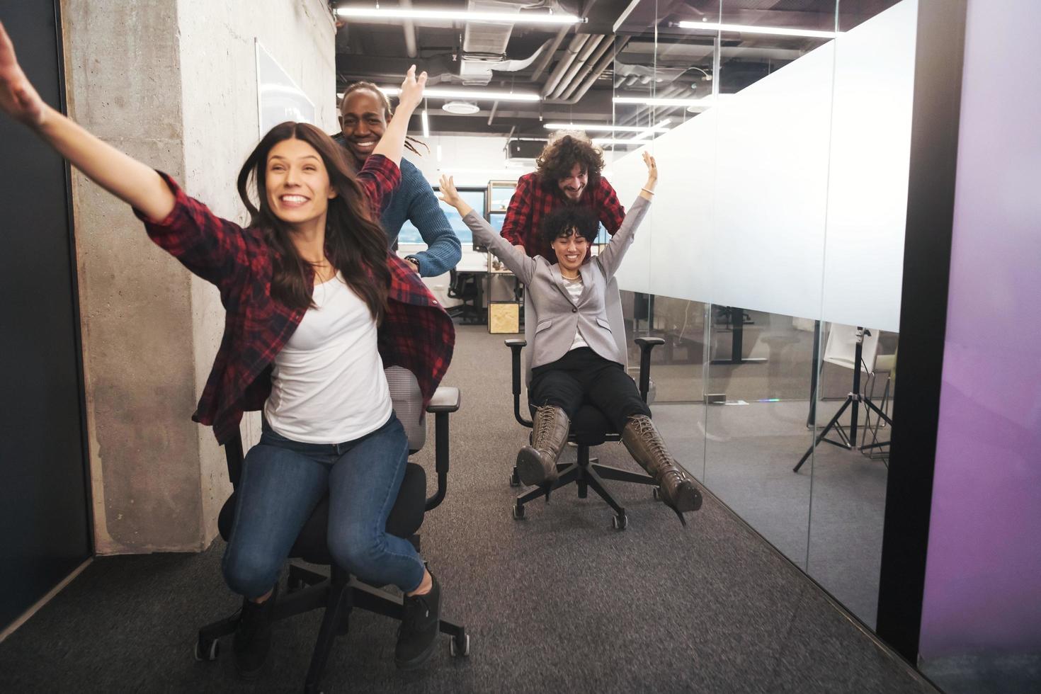 equipo de negocios multiétnico corriendo en sillas de oficina foto