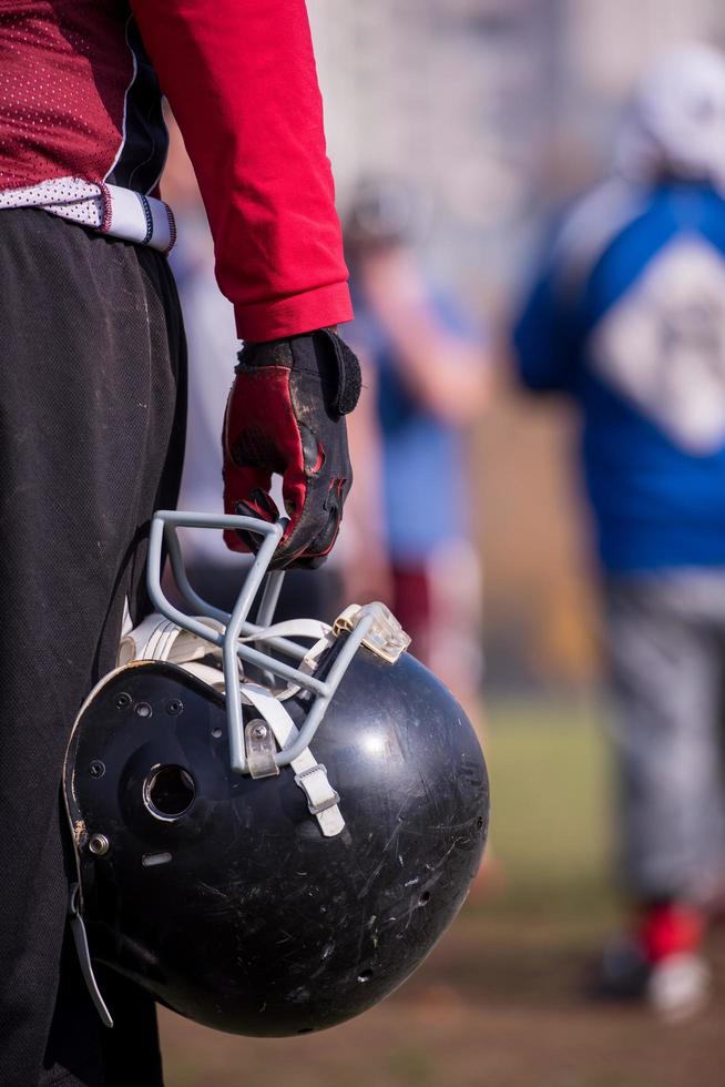 American football player holding helmet photo