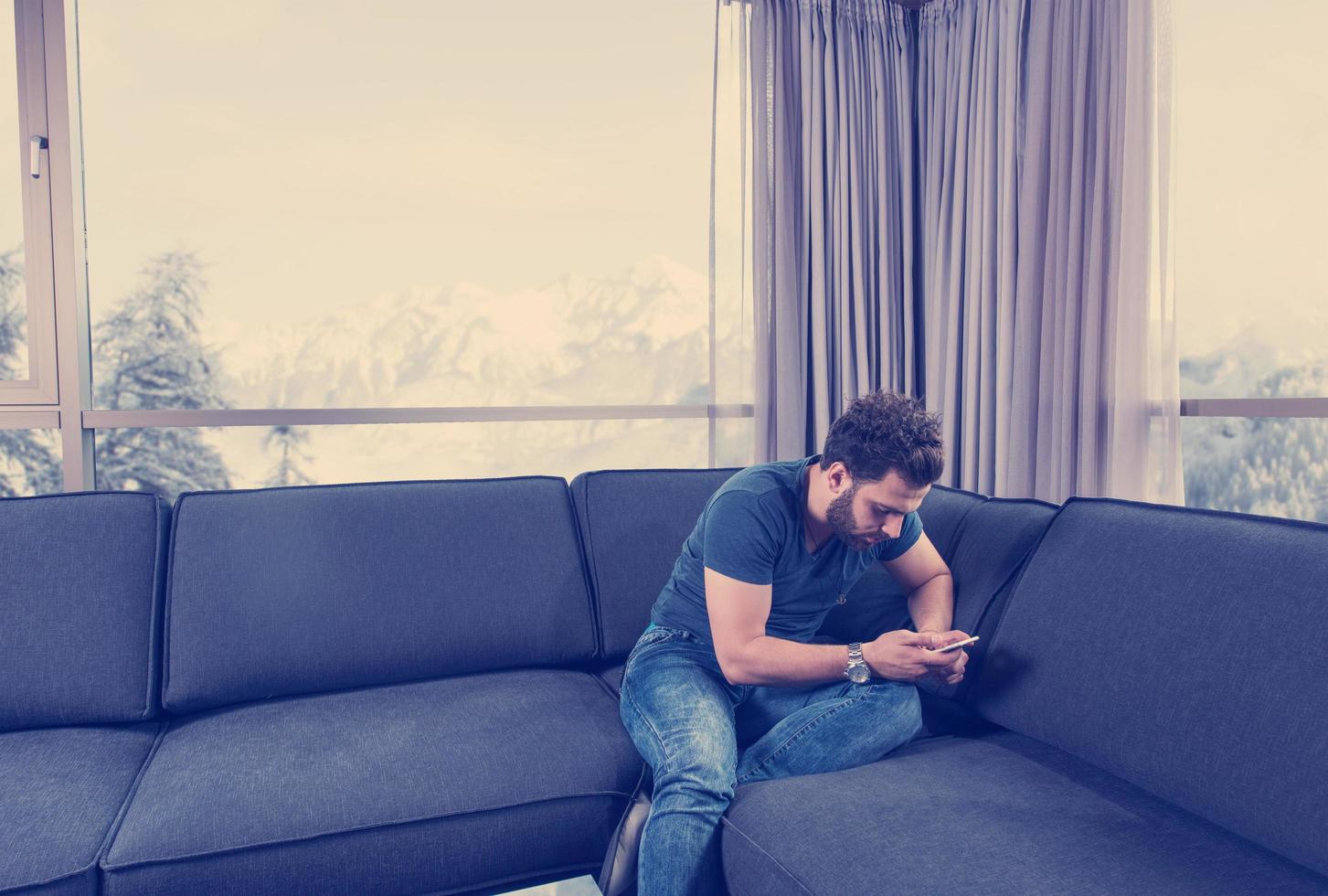 young casual man using a mobile phone at home photo