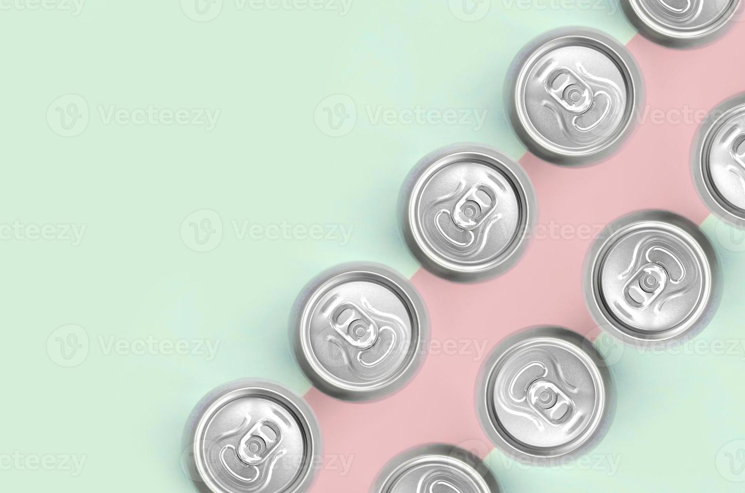 Many metallic beer cans on texture background of fashion pastel turquoise and pink colors photo