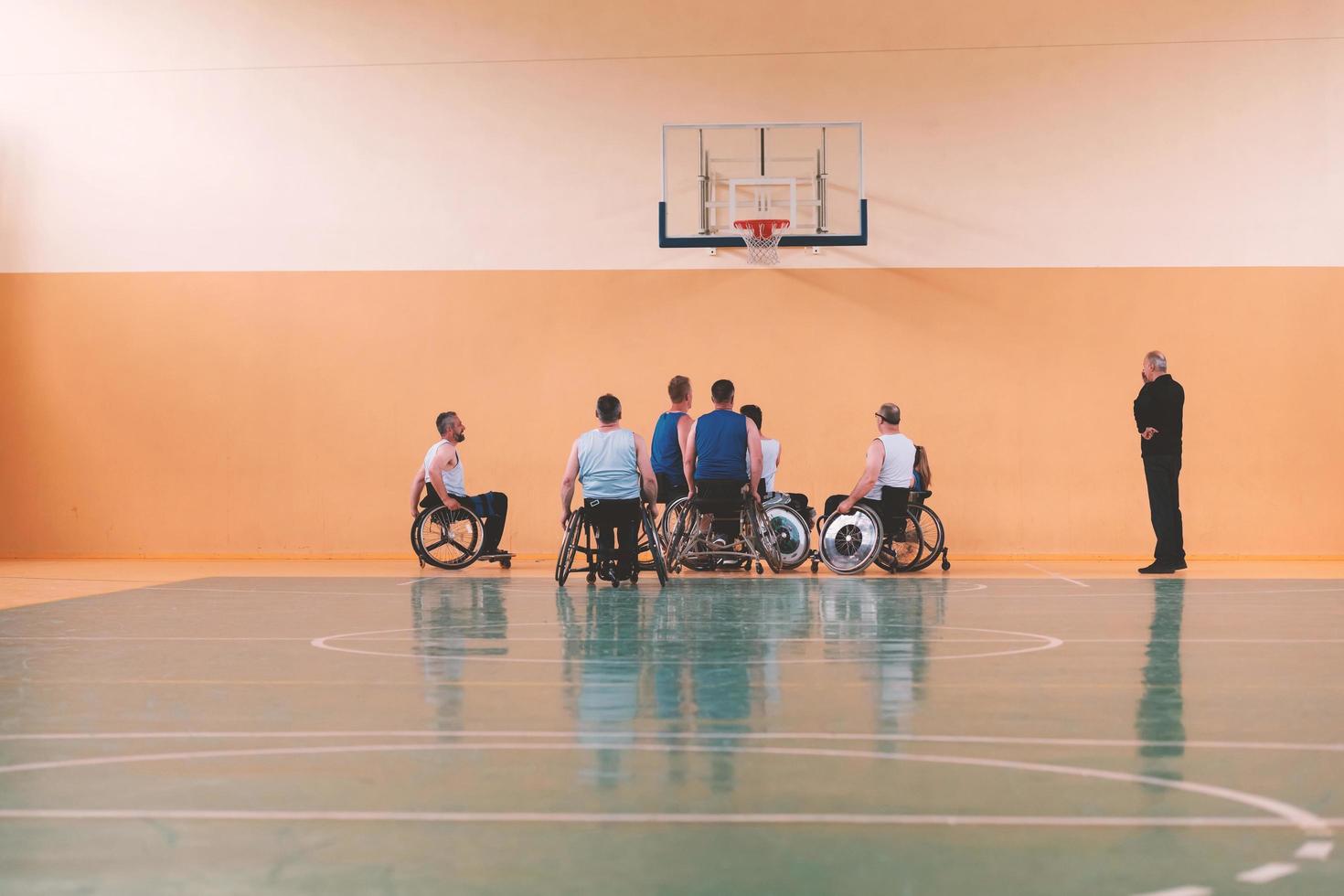 Disabled War veterans mixed race opposing basketball teams in wheelchairs photographed in action while playing an important match in a modern hall. photo