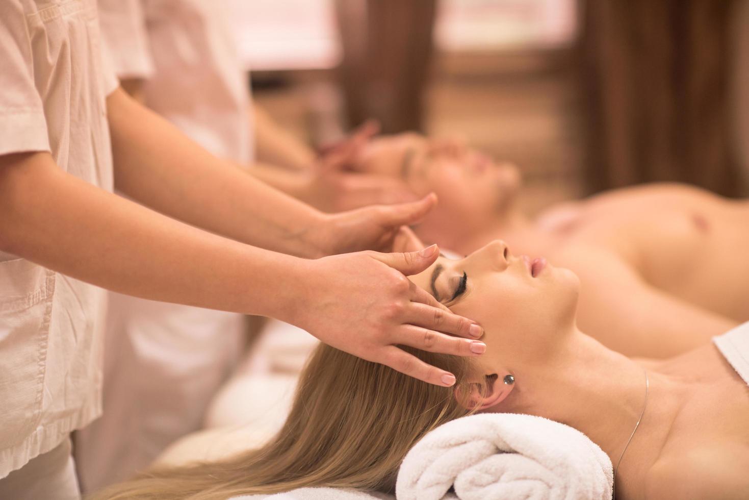 couple enjoying head massage at the spa photo