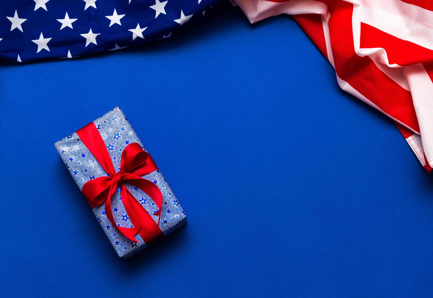 Happy Veterans Day concept. American flags with gift box against a blackboard background. November 11. photo