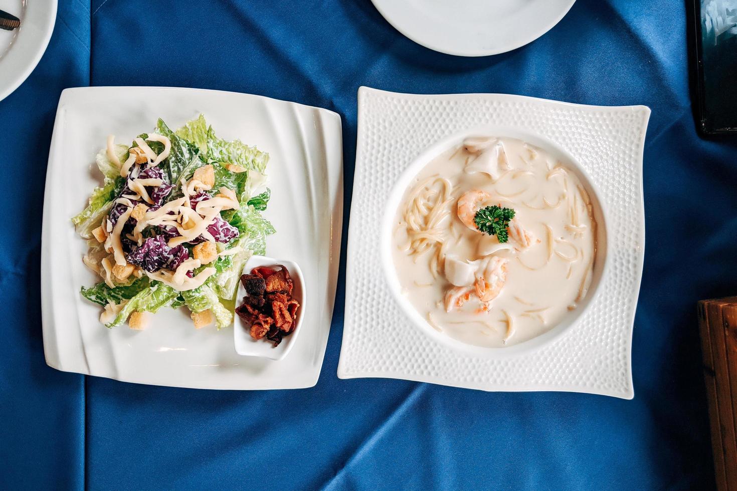 salad cesar and sea food spaghetti flat lay. Top view table of Italian food. photo