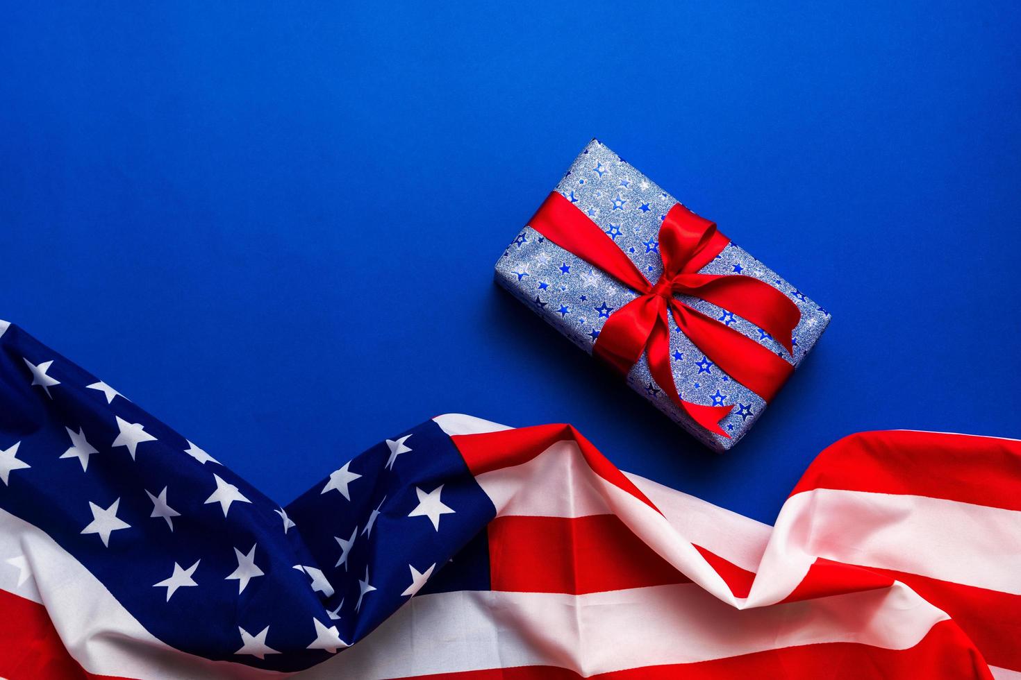 Happy Veterans Day concept. American flags with gift box against a blackboard background. November 11. photo